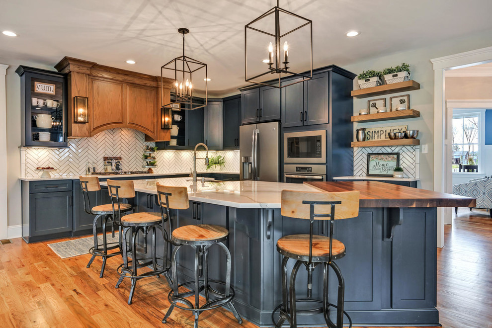 Transitional l-shaped separate kitchen in Richmond with shaker cabinets, blue cabinets, white splashback, stainless steel appliances, medium hardwood floors, with island and white benchtop.