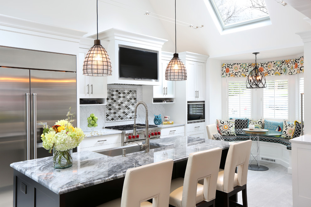 Kitchen - mid-sized transitional single-wall porcelain tile kitchen idea with an undermount sink, recessed-panel cabinets, white cabinets, marble countertops, white backsplash, stone slab backsplash, stainless steel appliances and an island