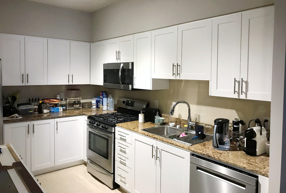 Photo of a mid-sized midcentury u-shaped open plan kitchen in Toronto with an undermount sink, shaker cabinets, white cabinets, quartz benchtops, beige splashback, glass tile splashback, stainless steel appliances, cement tiles, with island, beige floor and brown benchtop.