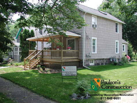 This is an example of a mid-sized country front yard verandah in Detroit with decking and a roof extension.