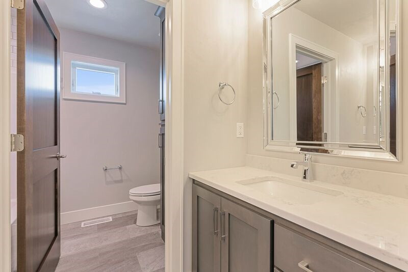 Alcove bathtub - transitional kids' vinyl floor and gray floor alcove bathtub idea with shaker cabinets, gray cabinets, a two-piece toilet, gray walls, an undermount sink, quartz countertops and white countertops