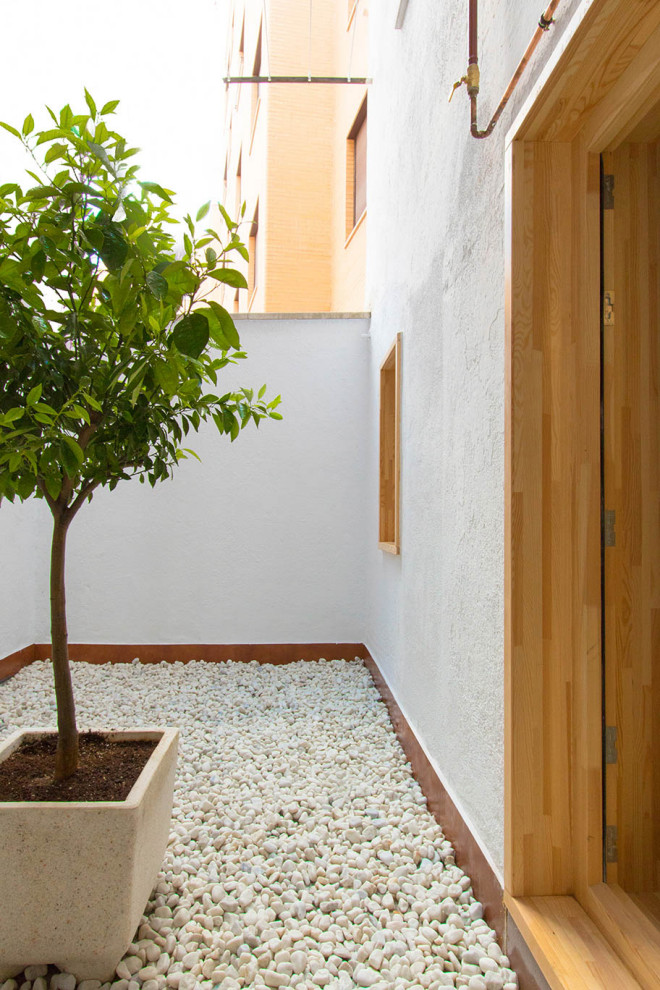 Design ideas for a small scandinavian backyard patio in Madrid with gravel.