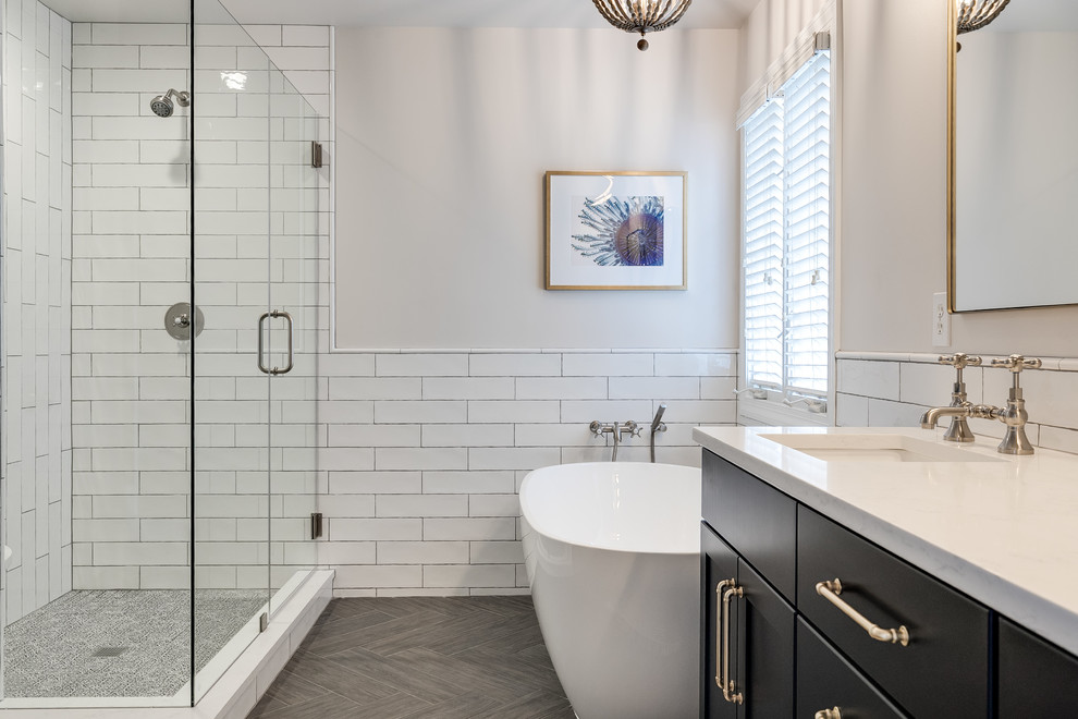 Large contemporary master bathroom in Richmond with recessed-panel cabinets, blue cabinets, a freestanding tub, a corner shower, a two-piece toilet, white tile, subway tile, white walls, porcelain floors, an undermount sink, engineered quartz benchtops, grey floor, a hinged shower door and white benchtops.