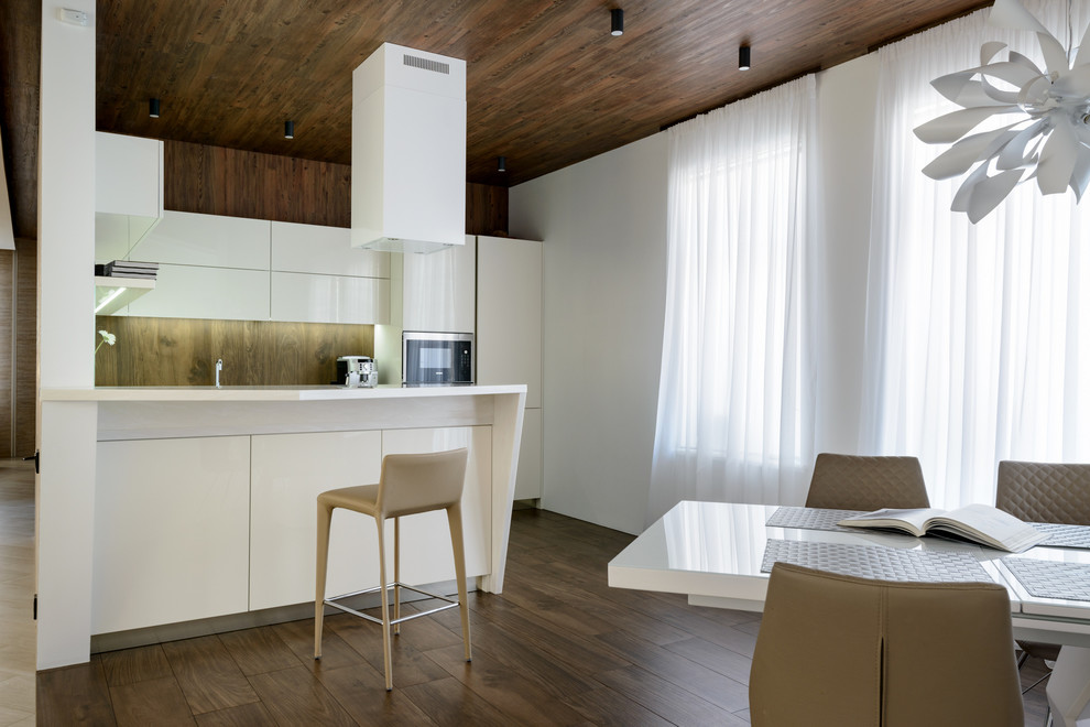 Inspiration for a contemporary eat-in kitchen in Moscow with flat-panel cabinets, white cabinets, brown splashback, window splashback, dark hardwood floors, a peninsula, brown floor and white benchtop.
