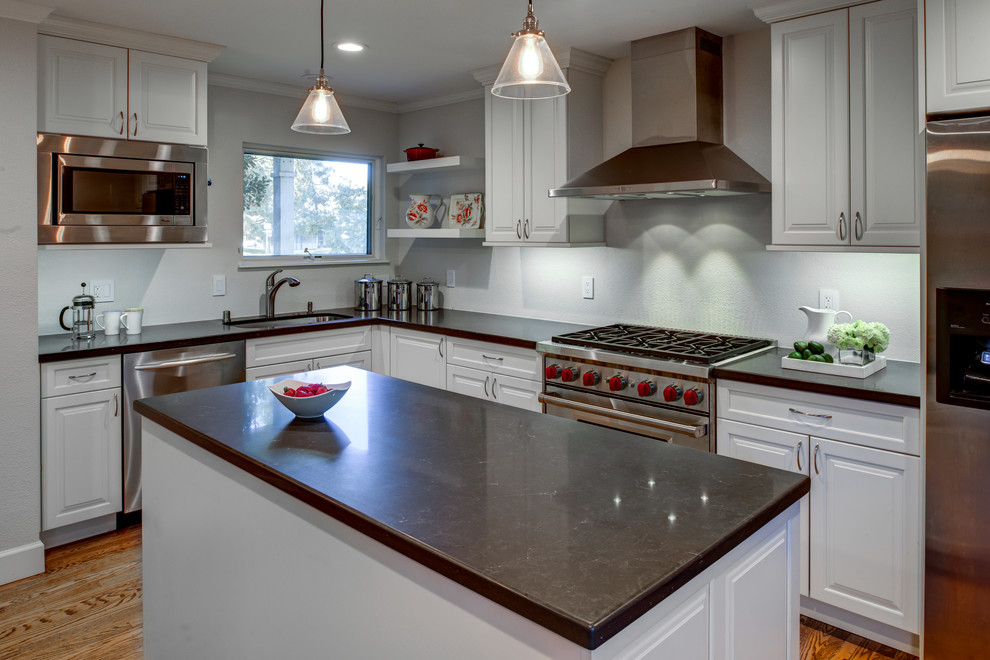 Design ideas for a mid-sized traditional l-shaped eat-in kitchen in San Francisco with an undermount sink, raised-panel cabinets, white cabinets, quartz benchtops, stainless steel appliances, light hardwood floors and with island.