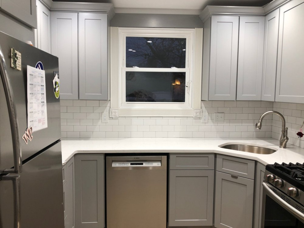 Design ideas for a transitional eat-in kitchen in New York with shaker cabinets, grey cabinets, quartz benchtops, white splashback, subway tile splashback, stainless steel appliances and white benchtop.
