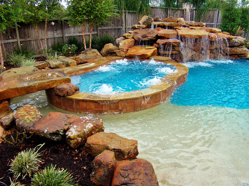 This is an example of a large modern backyard custom-shaped pool in Houston with a water feature and stamped concrete.
