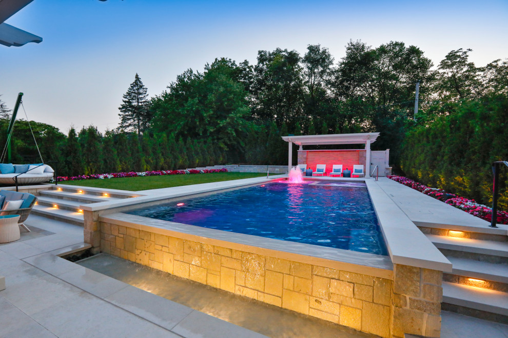 Design ideas for a medium sized classic back rectangular lengths swimming pool in Chicago with with pool landscaping and natural stone paving.
