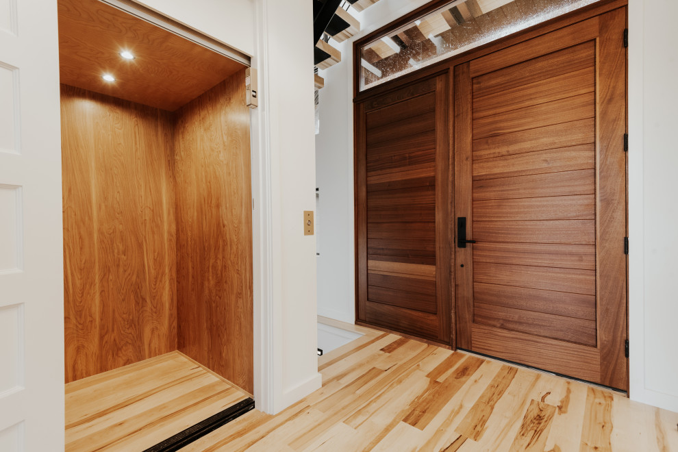 Front door - mid-sized transitional light wood floor front door idea with white walls and a medium wood front door