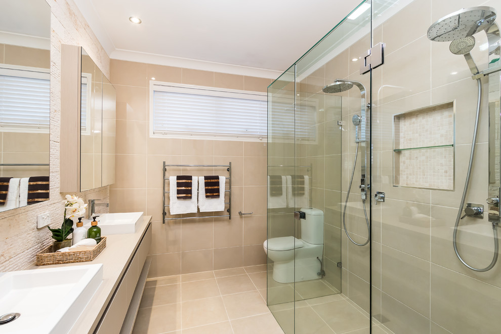 Inspiration for a contemporary master bathroom in Brisbane with flat-panel cabinets, beige cabinets, a curbless shower, a two-piece toilet, beige tile, beige walls, a drop-in sink and a hinged shower door.