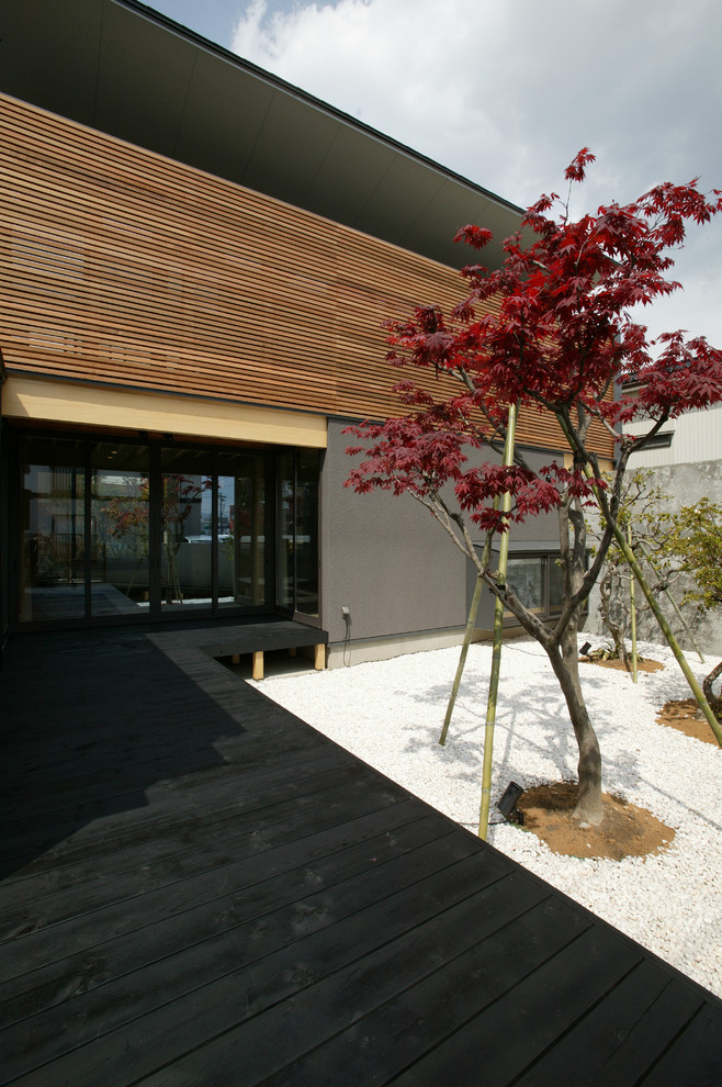 This is an example of a mid-sized asian courtyard patio in Other with decking and no cover.