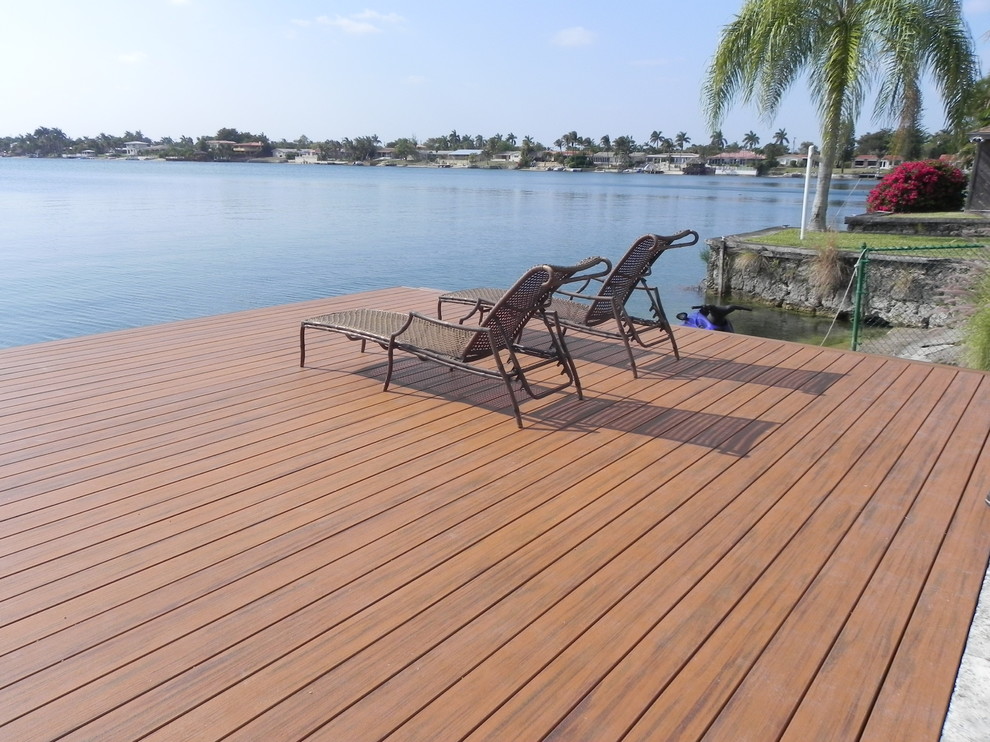 Design ideas for a mid-sized beach style backyard deck in Miami with with dock and no cover.