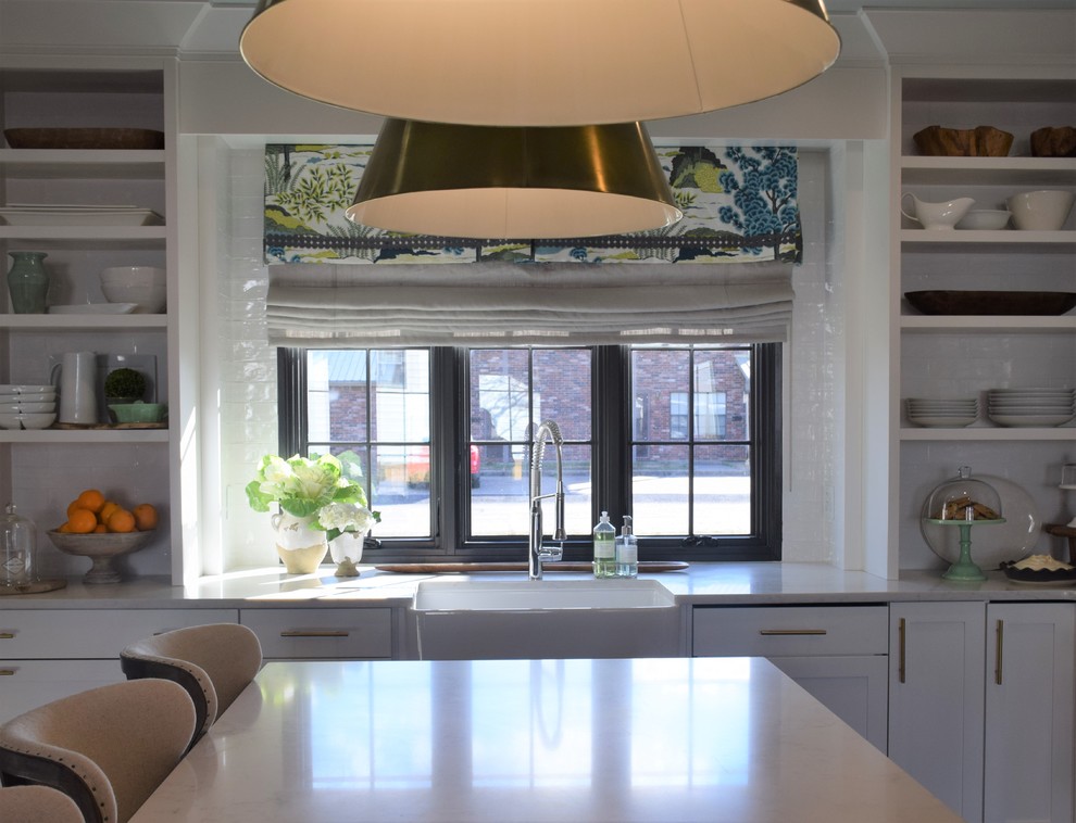 Inspiration for a large transitional dark wood floor eat-in kitchen remodel with a farmhouse sink, shaker cabinets, white cabinets, quartzite countertops, white backsplash, subway tile backsplash, stainless steel appliances and an island