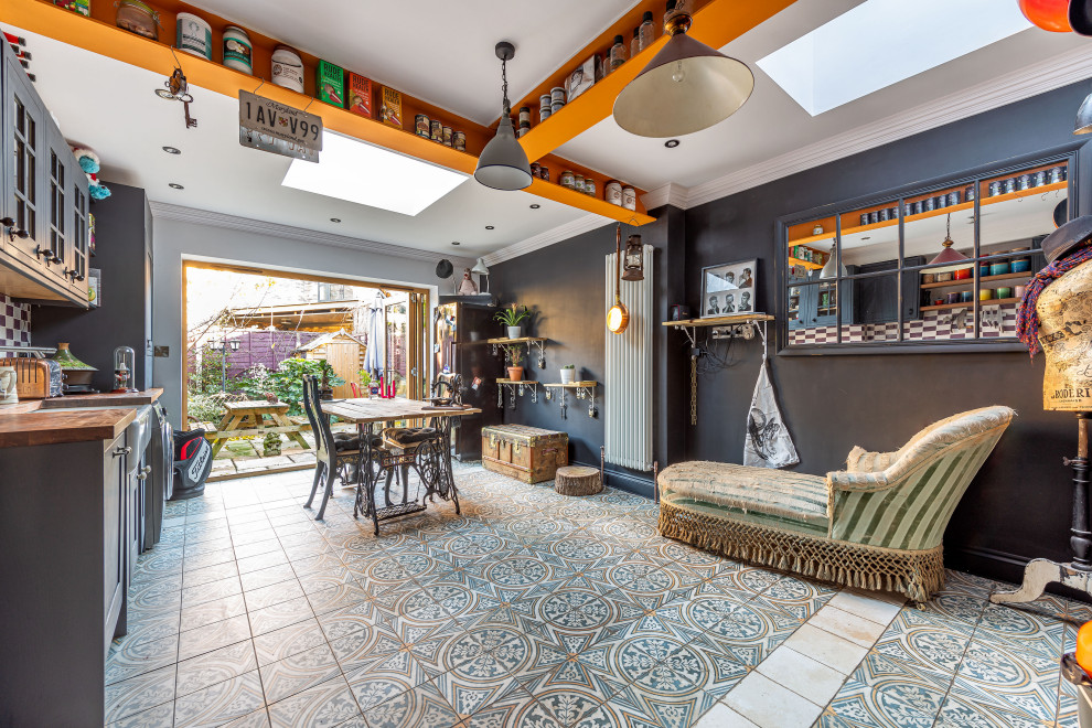 Foto på ett eklektiskt linjärt kök och matrum, med en rustik diskho, skåp i shakerstil, grå skåp, träbänkskiva, flerfärgad stänkskydd, stänkskydd i keramik, svarta vitvaror, klinkergolv i porslin och flerfärgat golv