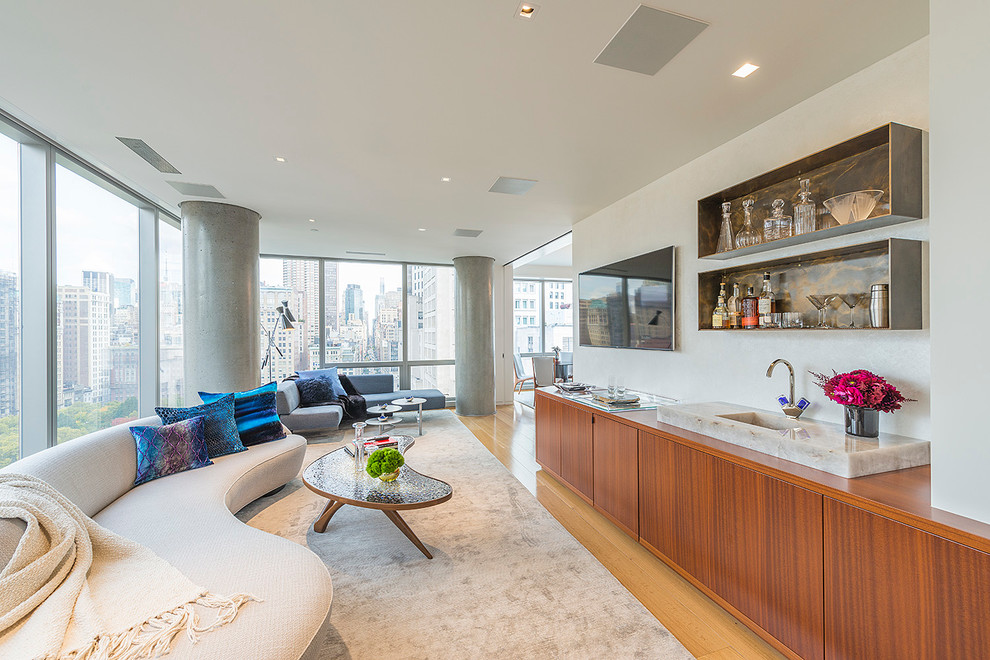 Inspiration for a contemporary family room in New York with a home bar and light hardwood floors.
