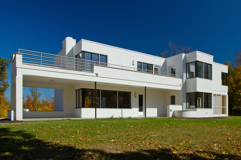Photo of a mid-sized contemporary two-storey white exterior in Cincinnati with a flat roof.