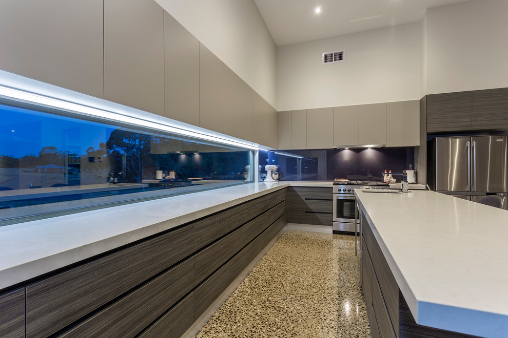 This is an example of a contemporary eat-in kitchen in Geelong with quartz benchtops, stainless steel appliances, concrete floors and with island.