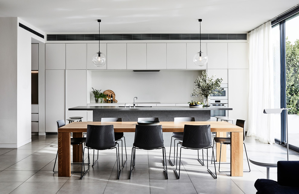 Design ideas for a contemporary open plan dining in Melbourne with white walls and grey floor.