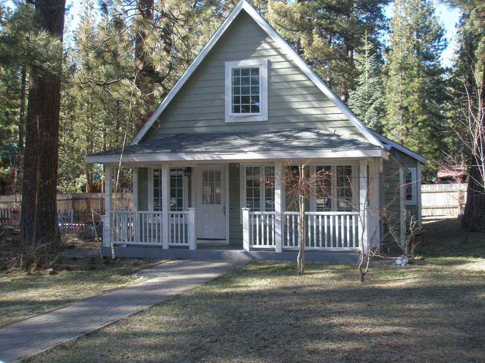 Photo of a mid-sized traditional two-storey green house exterior in Other with vinyl siding, a gable roof and a shingle roof.