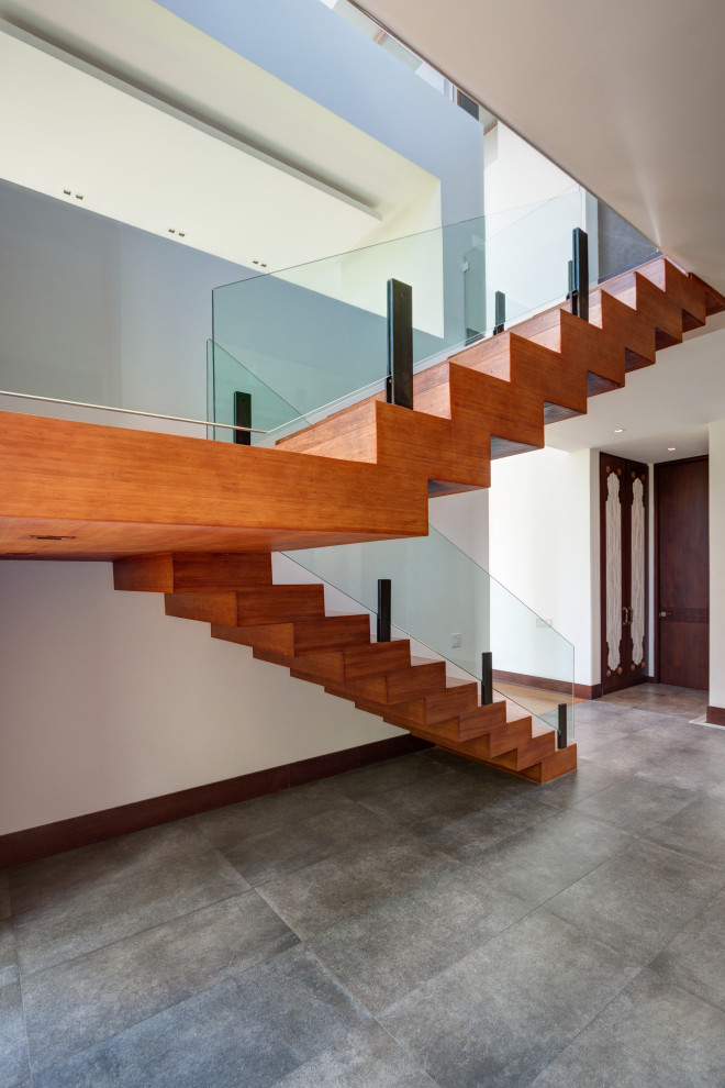 Свежая идея для дизайна: большая п-образная деревянная лестница в стиле модернизм с деревянными ступенями и стеклянными перилами - отличное фото интерьера