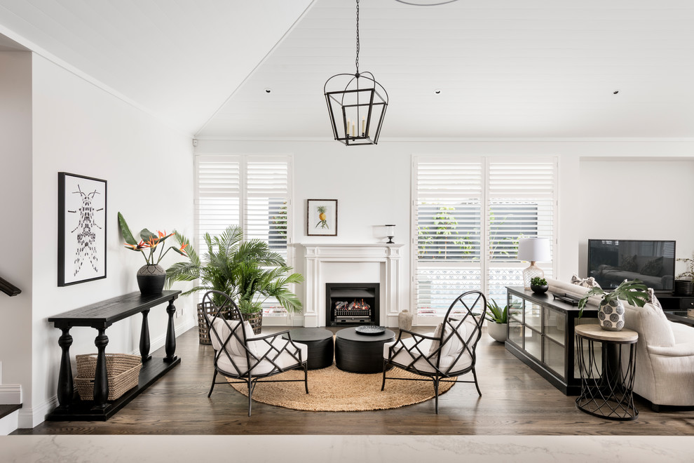 Inspiration for a large transitional formal living room in Perth with white walls, dark hardwood floors, a standard fireplace, a concrete fireplace surround, brown floor and a freestanding tv.