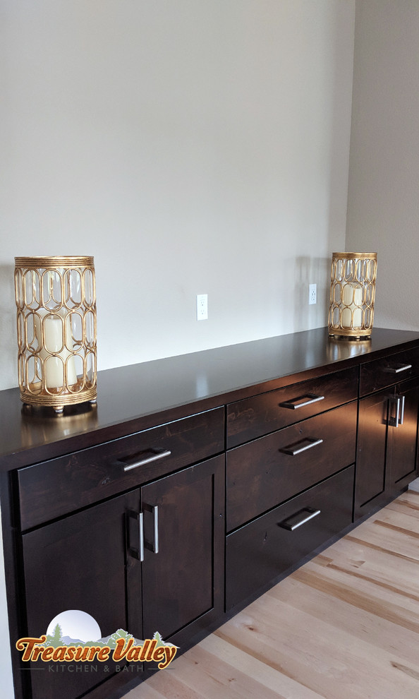 Example of a mid-sized transitional l-shaped light wood floor open concept kitchen design in Boise with a farmhouse sink, shaker cabinets, granite countertops, glass tile backsplash, stainless steel appliances and an island