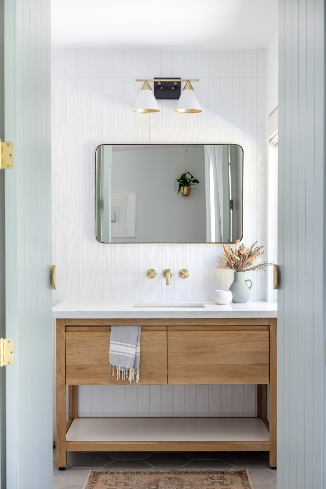 Inspiration for a medium sized modern bathroom in San Diego with grey floors, flat-panel cabinets, light wood cabinets, white tiles, ceramic tiles, white walls, porcelain flooring, a submerged sink, engineered stone worktops, white worktops, a single sink and a freestanding vanity unit.
