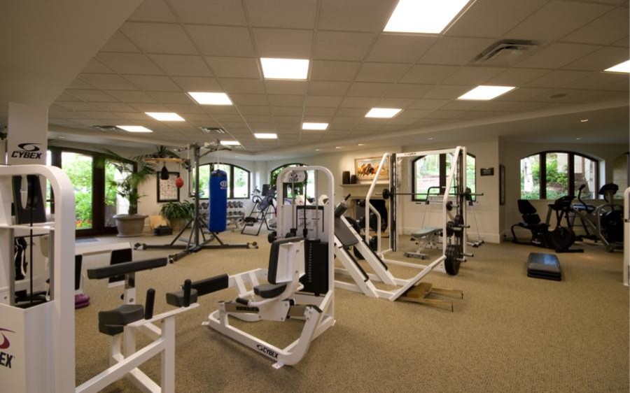 Expansive traditional multipurpose gym in Denver with white walls and carpet.