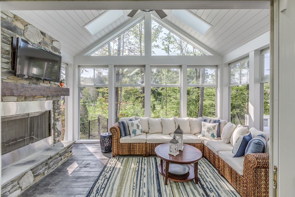 Photo of a traditional sunroom in Cleveland with a standard fireplace, a metal fireplace surround, a skylight, grey floor and painted wood floors.