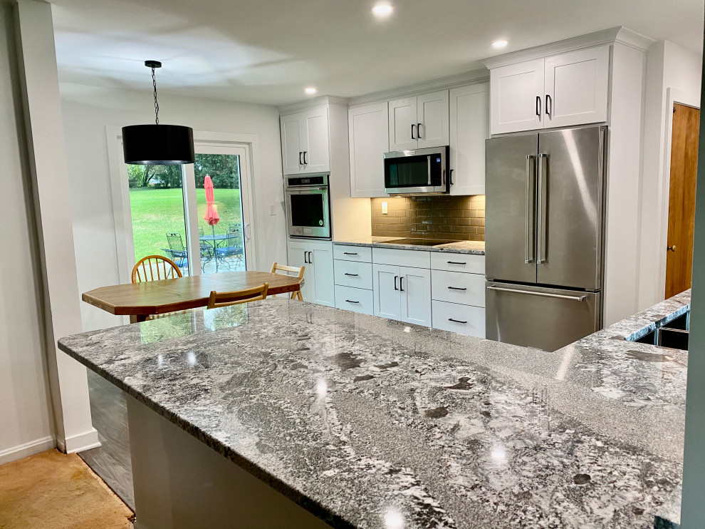 Small transitional u-shaped vinyl floor and gray floor eat-in kitchen photo in Milwaukee with a double-bowl sink, shaker cabinets, white cabinets, granite countertops, gray backsplash, glass tile backsplash, stainless steel appliances, a peninsula and gray countertops