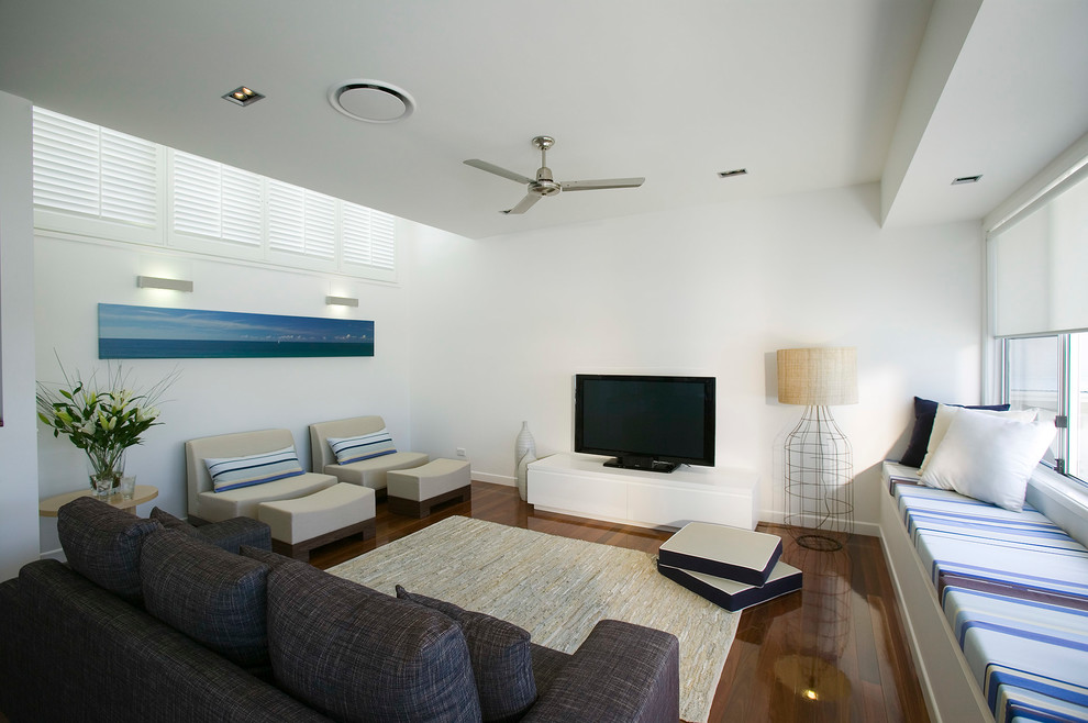 This is an example of a mid-sized contemporary open concept living room in Sunshine Coast with white walls, medium hardwood floors and a freestanding tv.