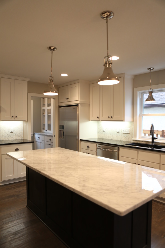 Example of a large transitional l-shaped dark wood floor and brown floor open concept kitchen design in Minneapolis with an undermount sink, shaker cabinets, white cabinets, quartzite countertops, white backsplash, stainless steel appliances, an island, white countertops and stone slab backsplash