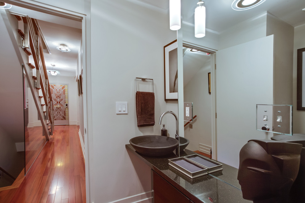 Small contemporary powder room in DC Metro with a vessel sink, flat-panel cabinets, black cabinets, granite benchtops, a two-piece toilet, grey walls and dark hardwood floors.