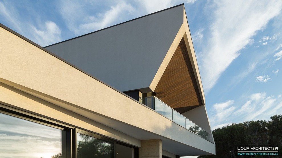 Design ideas for a mid-sized contemporary two-storey concrete beige house exterior in Melbourne with a flat roof.