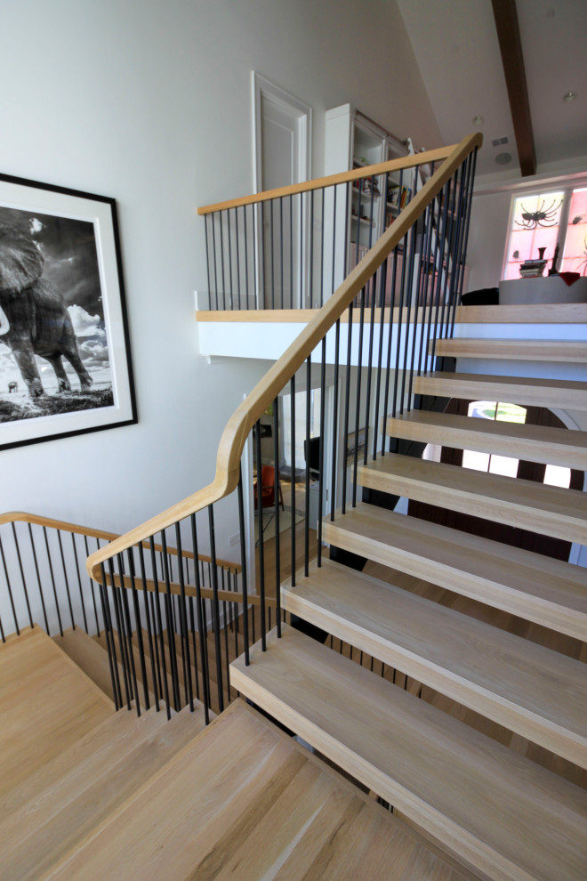 This is an example of an expansive modern wood floating staircase in DC Metro with mixed railing and planked wall panelling.