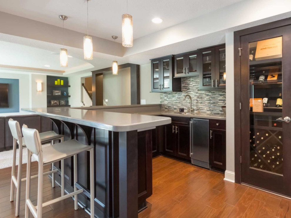 Small transitional l-shaped medium tone wood floor open concept kitchen photo in Orange County with an undermount sink, shaker cabinets, dark wood cabinets, stainless steel countertops, multicolored backsplash, mosaic tile backsplash, stainless steel appliances and a peninsula