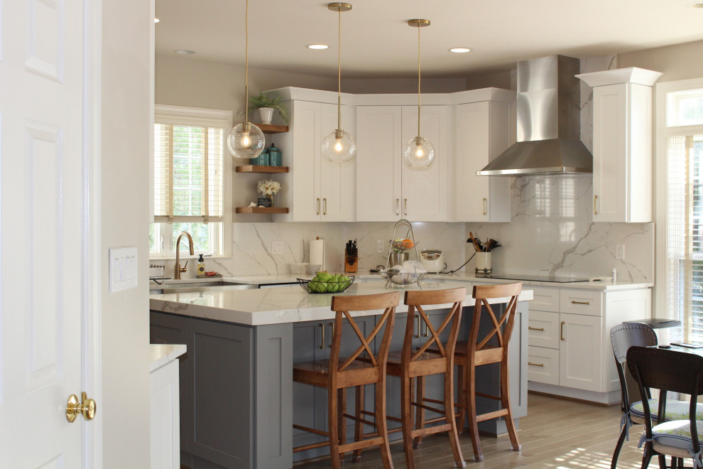 Eat-in kitchen - large modern galley laminate floor and brown floor eat-in kitchen idea in Raleigh with a farmhouse sink, shaker cabinets, white cabinets, quartz countertops, white backsplash, quartz backsplash, stainless steel appliances, an island and white countertops