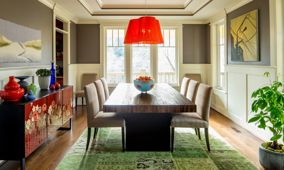 Eclectic medium tone wood floor enclosed dining room photo in Portland with gray walls