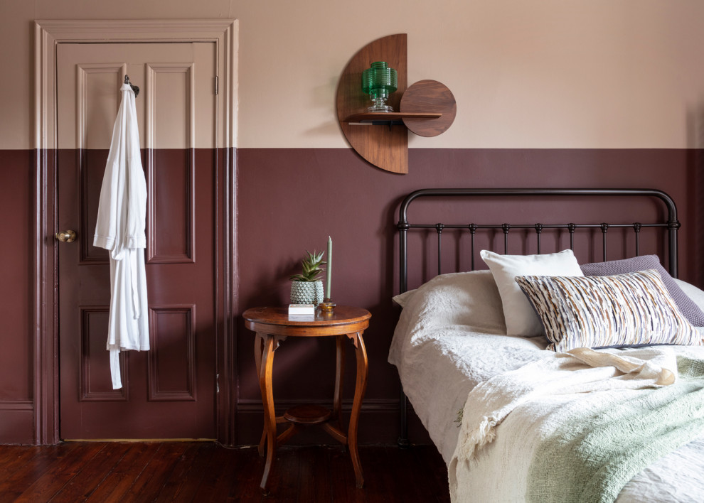 На фото: спальня среднего размера в стиле фьюжн с деревянным полом, стандартным камином, фасадом камина из плитки, коричневым полом и панелями на части стены