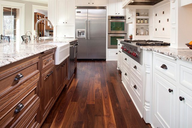 This is an example of a large traditional galley eat-in kitchen in Minneapolis with a farmhouse sink, beaded inset cabinets, white cabinets, granite benchtops, white splashback, ceramic splashback, dark hardwood floors and with island.