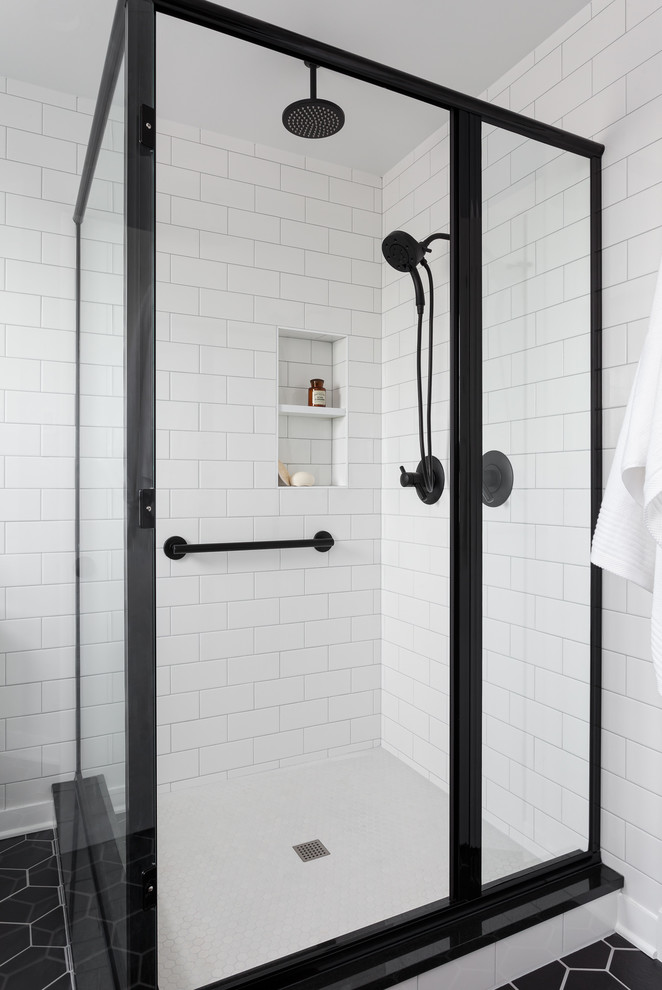 Inspiration for a mid-sized transitional master bathroom in Seattle with shaker cabinets, medium wood cabinets, a corner shower, a one-piece toilet, black and white tile, ceramic tile, grey walls, porcelain floors, an undermount sink, engineered quartz benchtops, black floor and a hinged shower door.