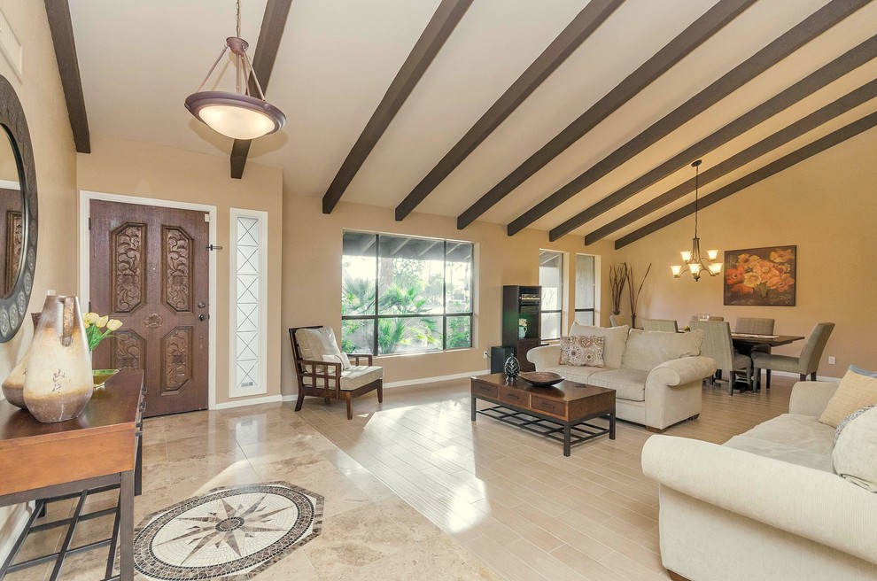 This is an example of a large mediterranean formal open concept living room in Phoenix with beige walls and travertine floors.