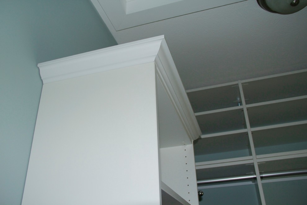 This is an example of a small gender-neutral built-in wardrobe in Grand Rapids with white cabinets and carpet.