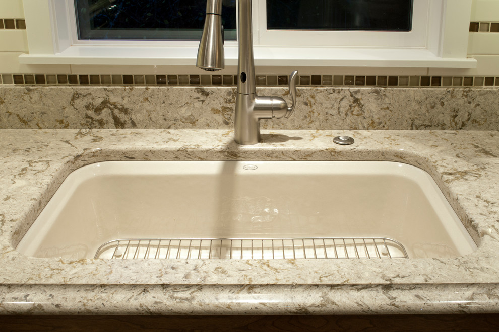 Inspiration for a small transitional u-shaped porcelain tile enclosed kitchen remodel in Seattle with an undermount sink, recessed-panel cabinets, dark wood cabinets, quartz countertops, beige backsplash, cement tile backsplash, stainless steel appliances and no island