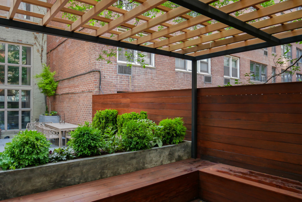 Foto de terraza planta baja minimalista de tamaño medio en patio trasero con fuente, pérgola y barandilla de varios materiales