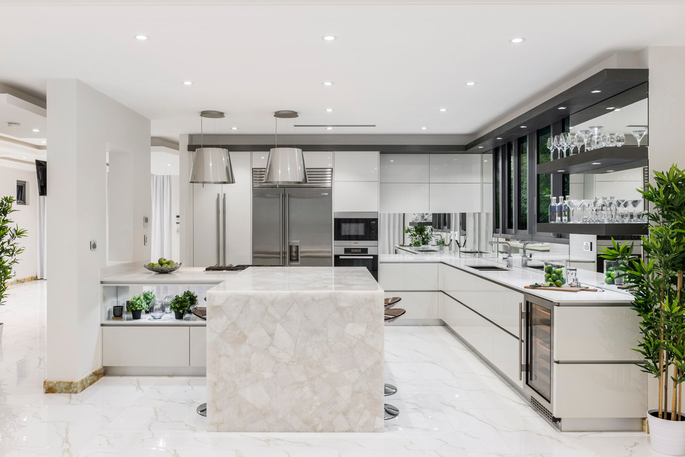 Design ideas for a contemporary l-shaped eat-in kitchen in Brisbane with an undermount sink, flat-panel cabinets, white cabinets, quartz benchtops, metallic splashback, mirror splashback, stainless steel appliances, marble floors and with island.