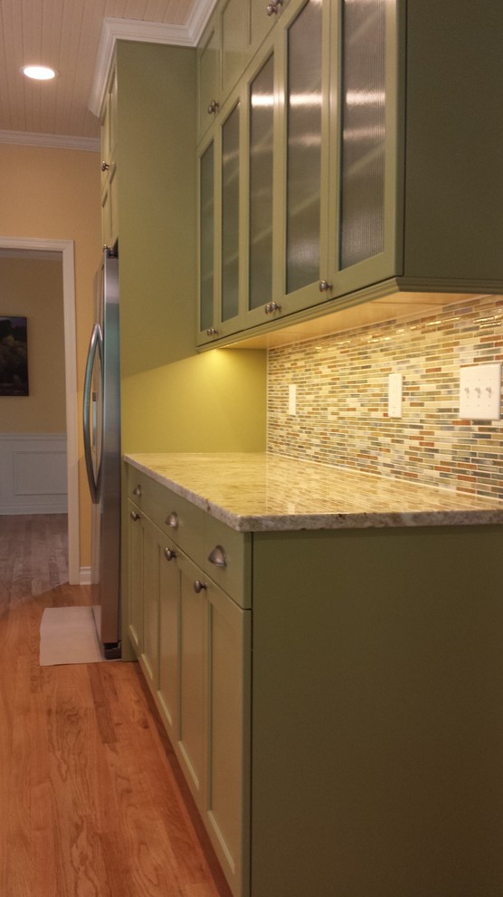 Large transitional u-shaped medium tone wood floor kitchen photo in Seattle with a double-bowl sink, recessed-panel cabinets, white cabinets, granite countertops, multicolored backsplash, mosaic tile backsplash, stainless steel appliances and an island