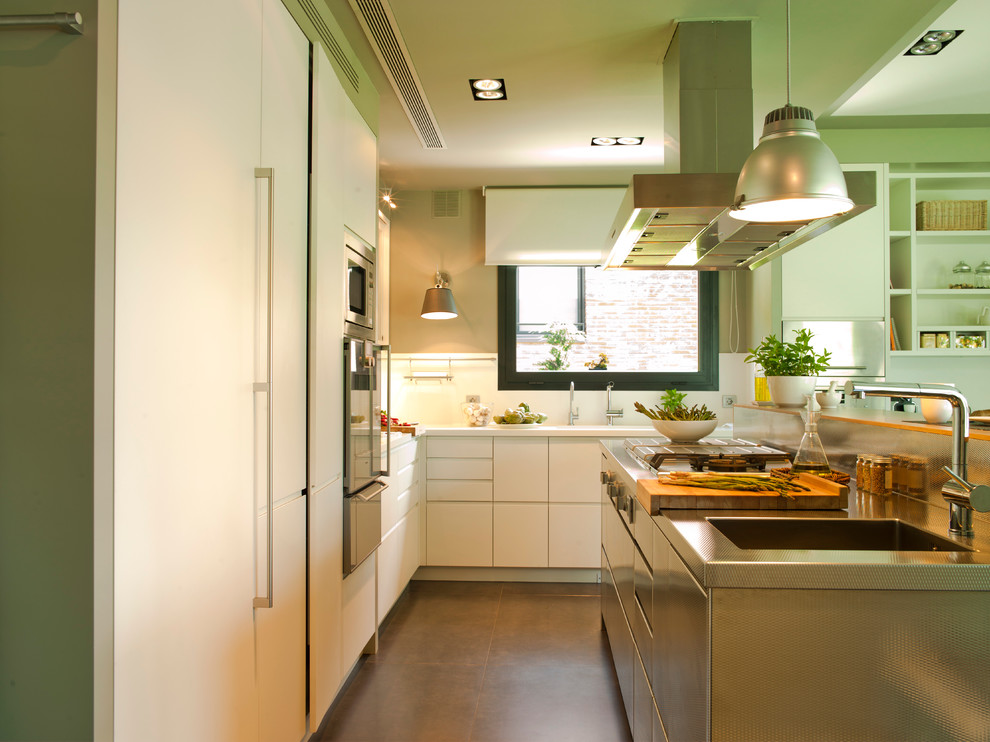 Design ideas for a large contemporary galley eat-in kitchen in Barcelona with an integrated sink, flat-panel cabinets, white cabinets, stainless steel benchtops, white splashback, stainless steel appliances, ceramic floors and with island.
