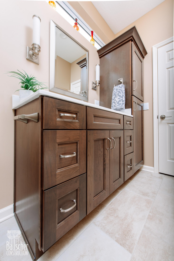 Photo of a small traditional master bathroom in Cincinnati with flat-panel cabinets, dark wood cabinets, an alcove shower, a two-piece toilet, beige tile, porcelain tile, beige walls, porcelain floors, an integrated sink, engineered quartz benchtops, beige floor, a hinged shower door, white benchtops, a shower seat, a single vanity and a built-in vanity.
