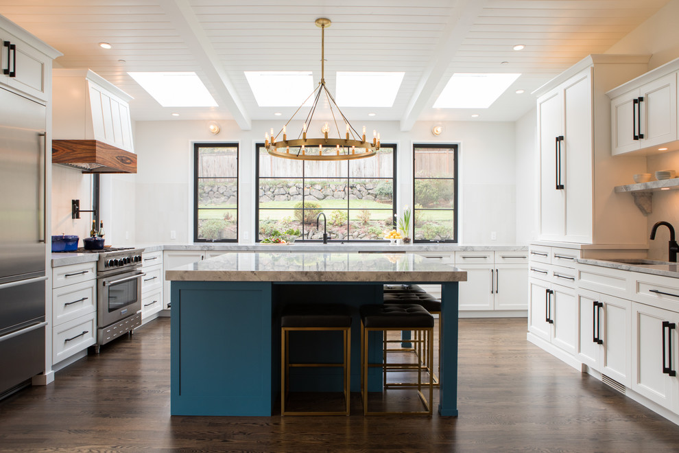 Inspiration for a large transitional u-shaped kitchen in Seattle with with island, recessed-panel cabinets, white cabinets, white splashback, stainless steel appliances, dark hardwood floors, brown floor and grey benchtop.